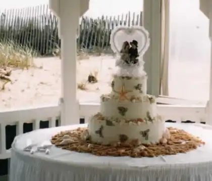 Beach wedding cake with bride and groom on the sand