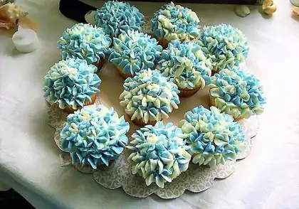 Cupcakes with blue and white frosting flowers