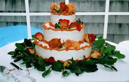 Tiered wedding cake with fresh orange and green flowers