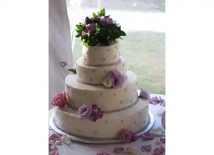 Four-tier wedding cake with purple fresh flowers