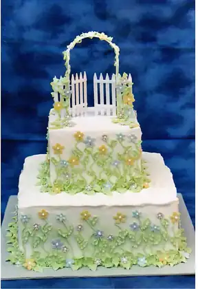 Garden themed cake with handmade flowers and a gate arch