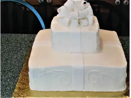White square wedding cake designed like a gift with a bow